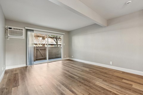 A room with a sliding glass door leading to a balcony.