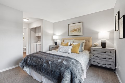 A bedroom with a bed, nightstands, and a painting on the wall.