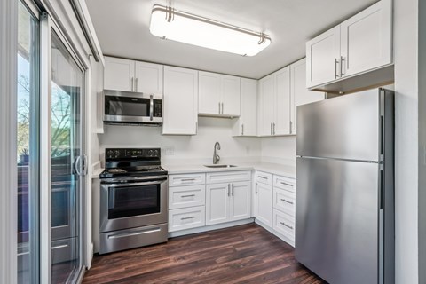 A modern kitchen with stainless steel appliances and white cabinets.