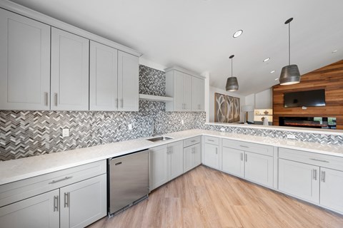 A kitchen with white cabinets and a wooden counter.