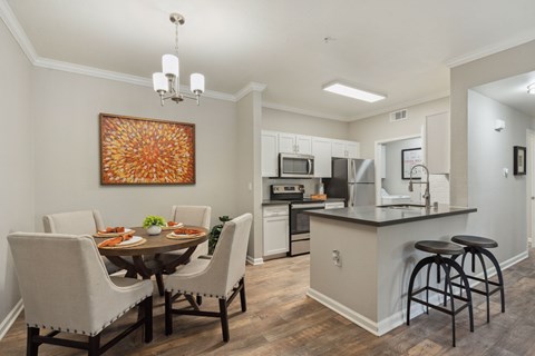 A kitchen with a dining table and chairs.