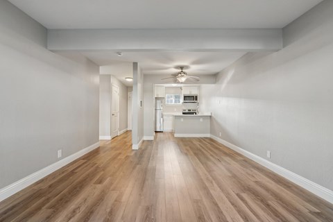 A long hallway with wood floors and white walls.