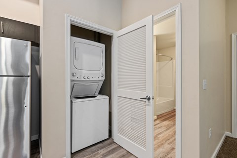 A white refrigerator is in a kitchen next to a white door.