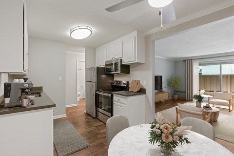 A modern kitchen with a dining table set with a floral centerpiece.