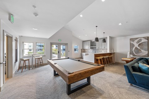 A room with a pool table and a couch.