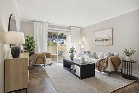 A modern living room with a large window, a sofa, and a coffee table.