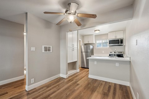 A kitchen with a refrigerator, microwave, and oven.