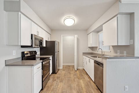 A kitchen with white cabinets and stainless steel appliances.