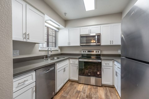 A kitchen with white cabinets and stainless steel appliances.