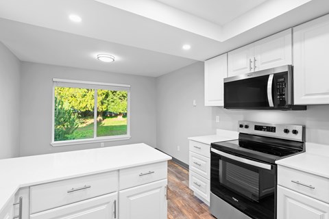 A kitchen with white cabinets and a black stove top oven.