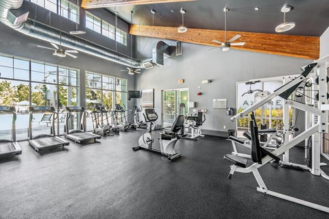 A spacious gym with treadmills, elliptical machines, and other exercise equipment.