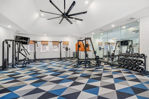 A gym with a variety of equipment and a checkered floor.