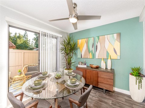 A dining room with a glass table and chairs.
