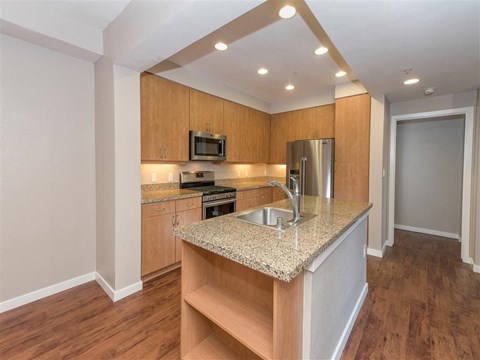 A kitchen with wooden cabinets and a granite countertop.