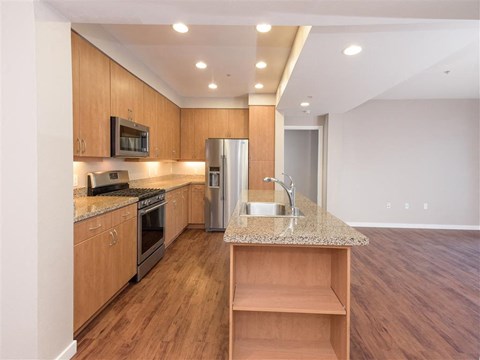 A kitchen with wooden cabinets and a granite countertop.