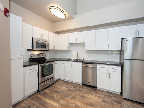 A kitchen with white cabinets and stainless steel appliances.