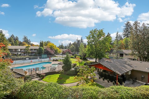 A view of a pool and a house from a hill.