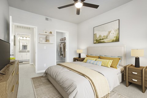 A bedroom with a large bed and a ceiling fan.
