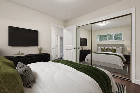 A bedroom with a large bed and a flat screen TV mounted on the wall.