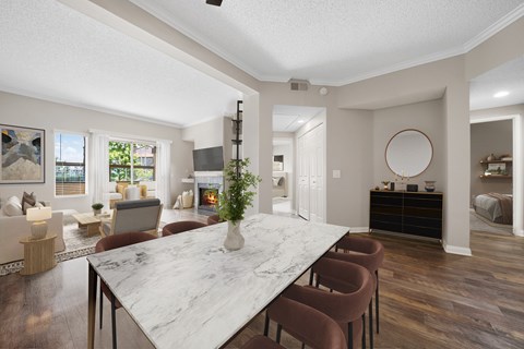A dining room with a marble table and chairs.