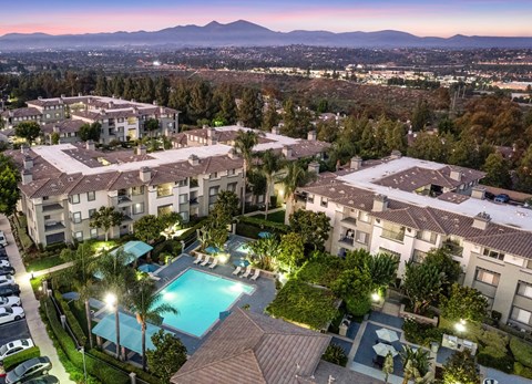 A large apartment complex with a pool and palm trees.