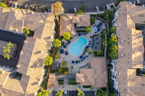 A bird's eye view of a residential area with a swimming pool.