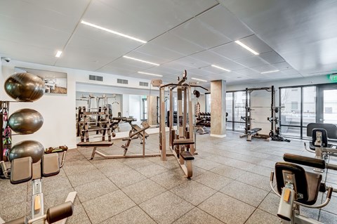 A gym with a variety of equipment including weights and machines.