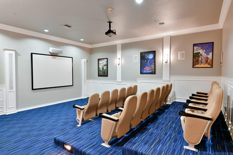 A room with a blue carpet and a white screen on the wall.