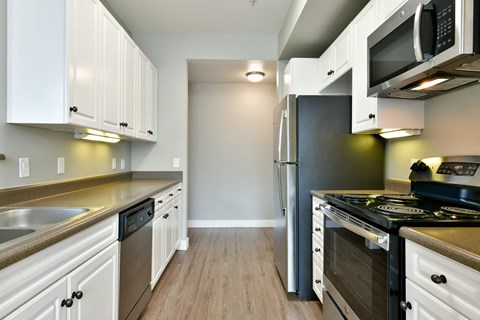 A kitchen with white cabinets and stainless steel appliances.