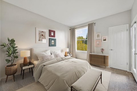A bedroom with a large bed and a potted plant.