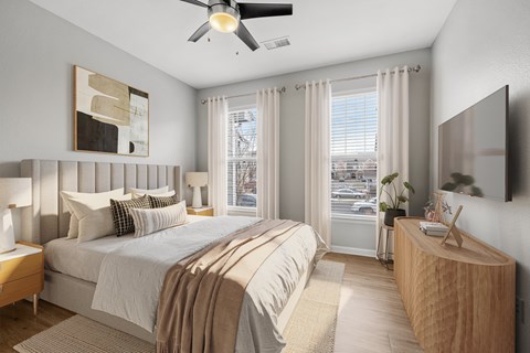 A bedroom with a large bed and a ceiling fan.
