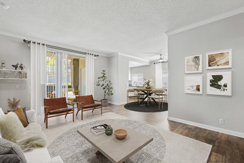 A living room with a grey couch, a coffee table, and a dining table with chairs.
