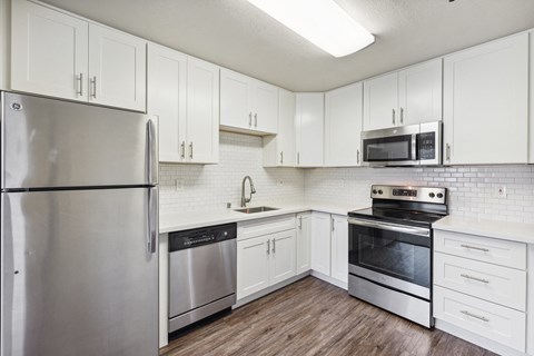 A kitchen with white cabinets and stainless steel appliances.