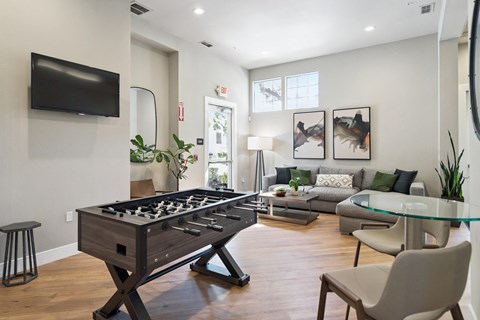 A modern living room with a pool table and a television.