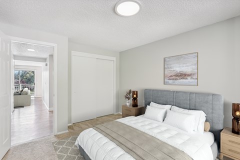 A bedroom with a large bed and a painting on the wall.