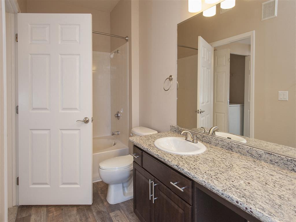A bathroom with a white door, a sink, and a mirror.