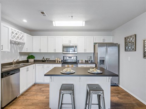 A kitchen with white cabinets and a black countertop.