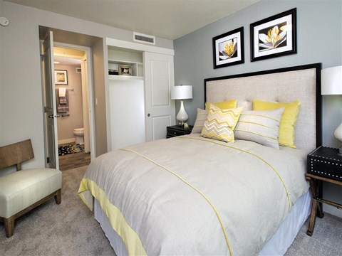 A bedroom with a large bed and a chair.