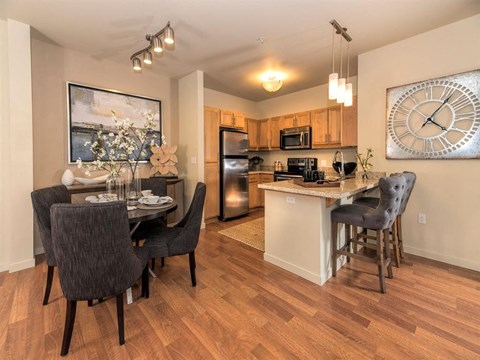 A kitchen with a dining table and chairs.