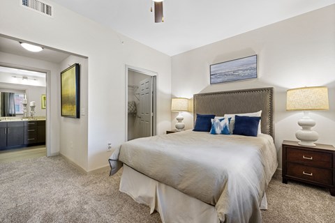 A bedroom with a large bed and a painting on the wall.