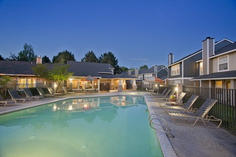 A swimming pool surrounded by lounge chairs at a resort.