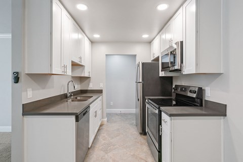 A kitchen with white cabinets and stainless steel appliances.