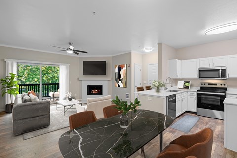 A modern kitchen with a black marble table and white cabinets.