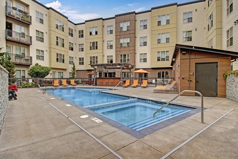 a swimming pool in front of a large apartment building
