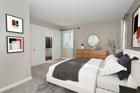 A bedroom with a large bed and a mirror on the wall.