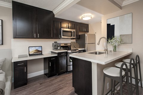 A kitchen with black cabinets and a white countertop.