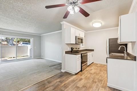 A kitchen with white cabinets and a brown countertop.