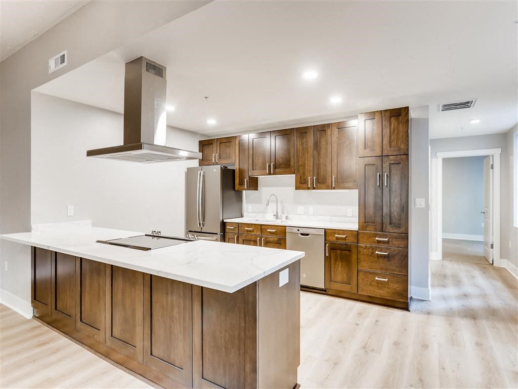 a large kitchen with wooden cabinets and a white counter top