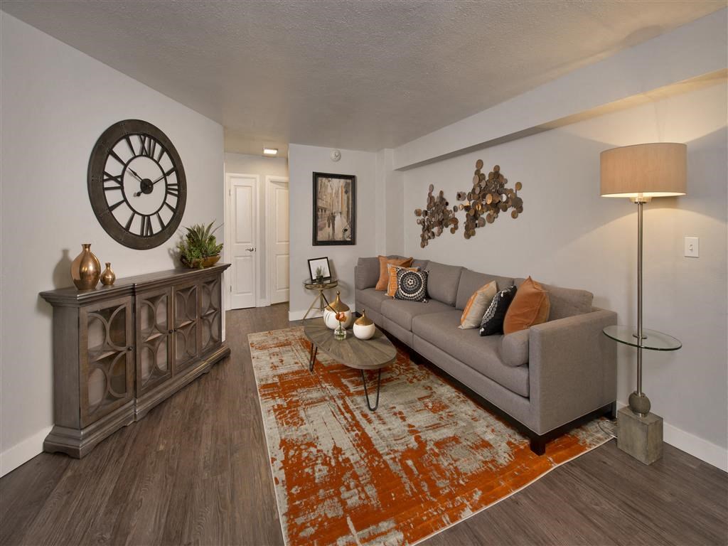 a living room with a couch and a clock on the wall