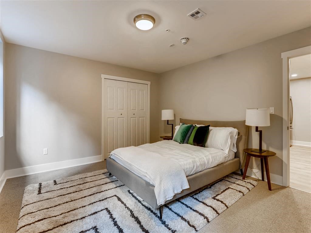 a bedroom with a bed and a rug